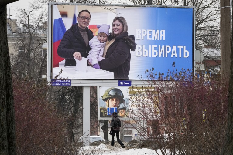 FILE - A woman walks past a billboard promoting the upcoming presidential election with the words in Russian "Time to vote" in St. Petersburg, Russia, Thursday, March 7, 2024. As Vladimir Putin heads for another six-year term as Russia’s president, there’s little electoral drama in the race. What he does after he crosses the finish line, however, is what’s drawing attention and, for many observers, provoking anxiety. (AP Photo/Dmitri Lovetsky, File)