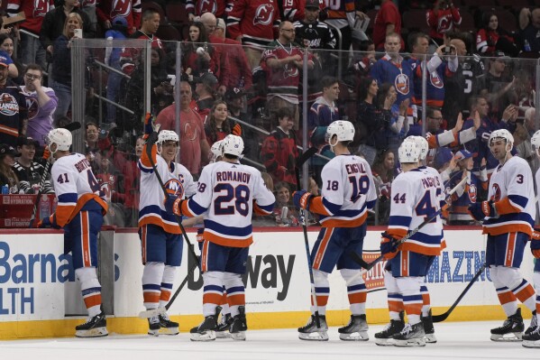 New York Islanders' Anders Lee, second from left, celebrates with teammates as they come off the ice after an NHL hockey game against the New Jersey Devils in Newark, N.J., Monday, April 15, 2024. (AP Photo/Seth Wenig)