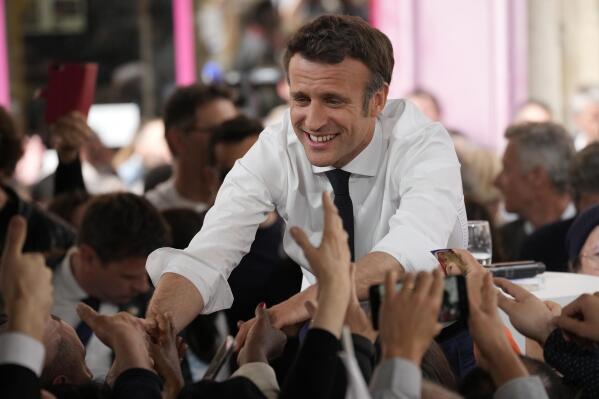 Centrist candidate and French President Emmanuel Macron shakes hands to residents after a campaign rally Friday, April 22, 2022 in Figeac, southwestern France. Emmanuel Macron is facing off against far-right challenger Marine Le Pen in France's April 24 presidential runoff. (AP Photo/Christophe Ena)