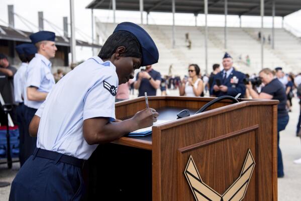 Airman 1st Class D'elbrah Assamoi, from Cote D'Ivoire, signs her U.S. certificate of citizenship after the Basic Military Training Coin Ceremony at Joint Base San Antonio-Lackland, in San Antonio, April 26, 2023. The U.S. military has struggled to overcome recruiting shortfalls and as a way to address that problem, it's stepping up efforts to sign up immigrants, offering a fast track to American citizenship to those who join the armed services. The Army and the Air Force have bolstered their marketing to entice legal residents to enlist. (Vanessa R. Adame/U.S. Air Force via AP)