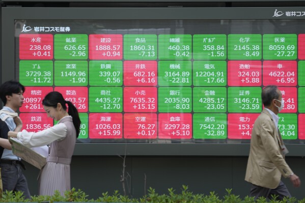 People walk past an electronic stock board showing Japan's sectors' stock indexes at a securities firm Tuesday, May 21, 2024 in Tokyo. Asian shares mostly fell Tuesday, even as most U.S. stock indexes finished higher, especially technology issues like Nvidia. (AP Photo/Shuji Kajiyama)