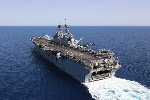 In this photo released by the U.S. Navy, the amphibious assault ship USS Bataan travels through the Red Sea, Tuesday, Aug. 8, 2023. Western-backed maritime forces in the Middle East on Saturday, Aug. 12, warned shippers traveling through the strategic Strait of Hormuz to stay as far away from Iranian territorial waters as possible to avoid being seized, a stark advisory amid heightened tensions between Iran and the U.S. (Mass Communication Specialist 3rd Class Riley Gasdia/U.S. Navy, via AP)