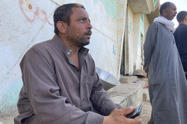 Ashraf Sadawy Abdel-Fattah sits outside his home in the farming village of Nazlet el-Sharif, Egypt, on Thursday, Sept. 14, 2023, as he talks about the death of his two sons who were killed in heavy flooding in the Libyan city of Derna, where they had moved for work. The village is mourning the deaths of dozens of its men in the floodwaters that tore through a city in neighbouring Libya. At least 74 bodies were brought back earlier this week for burial. (AP Photo/Samy Magdy)