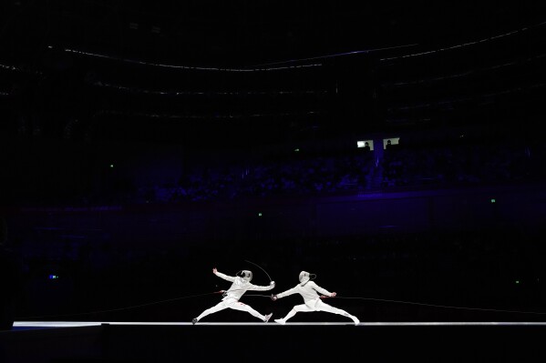 Liang Jianhao, left, of China competes against Kim Junho of South Korea during their men's sabre team finals fencing event of the 19th Asian Games in Hangzhou, China, Thursday, Sept. 28, 2023. (AP Photo/Aaron Favila)