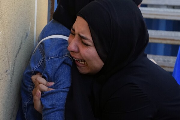 A relative of a journalist of pan-Arab TV network Al-Mayadeen, who was killed by an Israeli strike, mourn at a hospital in Beirut, Lebanon, Tuesday, Nov. 21, 2023. An Israeli strike on southern Lebanon killed Tuesday two journalists reporting for the Beirut-based Al-Mayadeen TV on the violence along the border with Israel, according to the Lebanese information minister and their TV station. (AP Photo/Bilal Hussein)