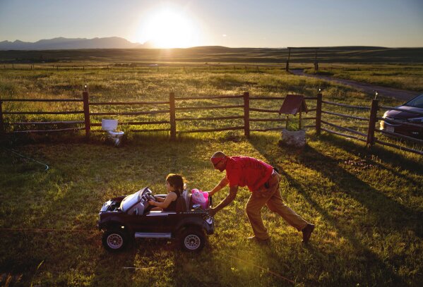 
              Randy Ortiz, right, pushes Ronnie Loring, 3, the cousin of Ashley HeavyRunner Loring, as they take a break from searching for her on the Blackfeet Indian Reservation in Browning, Mont., Thursday July 12, 2018. The family has logged about 40 searches but there's no way to cover a 1.5 million acre reservation, an expanse larger than Delaware. (AP Photo/David Goldman)
            