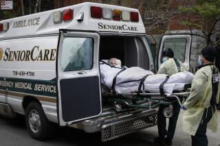 FILE - In this April 17, 2020, file photo, a patient is loaded into an ambulance by emergency medical workers outside Cobble Hill Health Center in the Brooklyn borough of New York. Deaths among Medicare patients in nursing homes soared by more than 30% last year, with two devastating surges eight months apart, a government watchdog reported Tuesday in the most complete assessment yet of the ravages of COVID-19 among its most vulnerable victims. (AP Photo/John Minchillo, File)