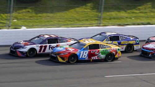 FILE - Denny Hamlin (11) and Kyle Busch (18) lead Chase Elliott (9), right, on a restart late in the NASCAR Cup Series auto race at Pocono Raceway, with Sunday, July 24, 2022, in Long Pond, Pa. Hamlin and Busch return to Pocono Raceway a year after they suffered disqualifications and had their 1-2 finishes thrown out. (AP Photo/Matt Slocum, File)