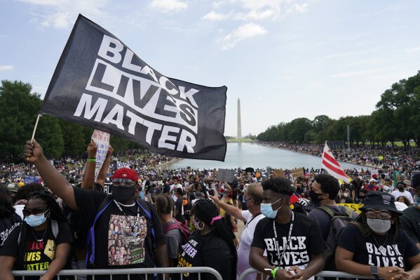 FILE - In this Aug. 28, 2020 file photo, people attend the March on Washington, Friday Aug. 28, 2020, in Washington, on the 57th anniversary of the Rev. Martin Luther King Jr.'s "I Have A Dream" speech. A convergence of three unprecedented, simultaneous national crises — the coronavirus pandemic, joblessness and police brutality — has led many to believe this presidential election is a referendum on race relations in America.  (AP Photo/Carolyn Kaster)