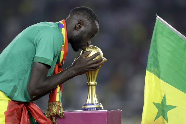 FILE - Senegal's Cheikhou Kouyate kisses trophy after winning the African Cup of Nations 2022 final soccer match between Senegal and Egypt at the Ahmadou Ahidjo stadium in Yaounde, Cameroon, on Feb. 6, 2022. (AP Photo/Sunday Alamba)
