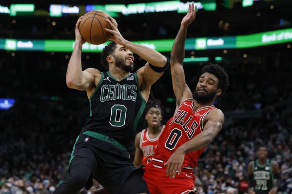 Boston Celtics' Jayson Tatum, left, shoots against Chicago Bulls' Coby White during the second half of an NBA basketball game, Saturday, Jan. 15, 2022, in Boston. (AP Photo/Michael Dwyer)