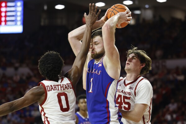 Kansas center Hunter Dickinson (1) goes against Oklahoma guard Le'Tre Darthard (0) and center Luke Northweather (45) during the first half of an NCAA college basketball game Saturday, Feb. 17, 2024, in Norman, Okla. (AP Photo/Garett Fisbeck)