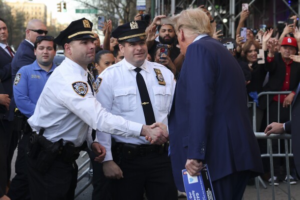 Former president Donald Trump, talks to New York Police officers after visiting a bodega, Tuesday, April 16, 2024, who's owner was attacked last year in New York. Fresh from a Manhattan courtroom, Donald Trump visited a New York bodega where a man was stabbed to death, a stark pivot for the former president as he juggles being a criminal defendant and the Republican challenger intent on blaming President Joe Biden for crime. Alba's attorney, Rich Cardinale, second from left, and Fransisco Marte, president of the Bodega Association, looked on. (AP Photo/Yuki Iwamura)
