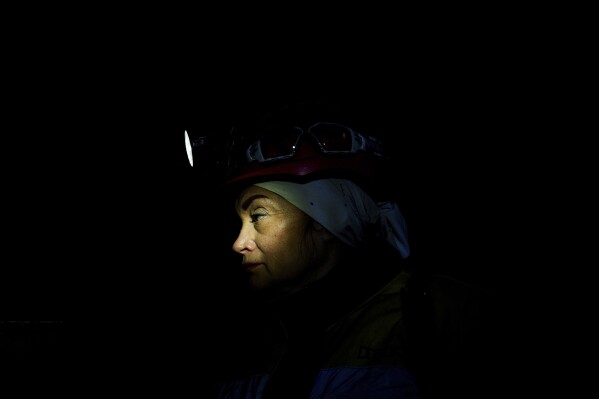 Oksana Polischuk, 51, descendes by lift into a coal mine in Dnipropetrovsk region, Ukraine, Jan. 30, 2025. Polischuk, lost her husband on a war, she became an IDP in Poland. She decided to return to Ukraine and be useful for her country working on a coal mine underground. (AP Photo/Evgeniy Maloletka)