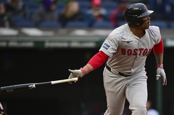 Boston Red Sox's Rafael Devers watches his solo home run off Cleveland Guardians starting pitcher Carlos Carrasco during the fifth inning of a baseball game Wednesday, April 24, 2024, in Cleveland. (AP Photo/David Dermer)