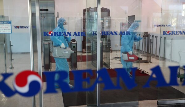 Workers wearing protective gears spray disinfectant as a precaution against the new coronavirus at Korean Air's Incheon Operation Center at Yeongjong Island, South Korea, Tuesday, Feb. 25, 2020. China and South Korea on Tuesday reported more cases of a new viral illness that has been concentrated in North Asia but is causing global worry as clusters grow in the Middle East and Europe. (Choe Jae-koo/Yonhap via AP)