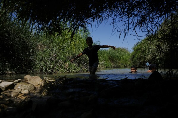 Children cool off in Ein Aviel springs near the community of Aviel, Israel, Thursday, July 13, 2023. (AP Photo/Ariel Schalit)