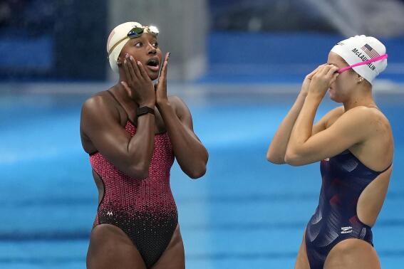 FILE - Simone Manuel of the United States, left, reacts with teammate Katie McLaughlin, right, at the pool during a swimming training session at the Tokyo Aquatics Centre at the 2020 Summer Olympics, Thursday, July 22, 2021, in Tokyo. A cap designed for Black swimmers’ natural hair that was banned from the Tokyo Olympics has been approved for competitive races. Swimming’s governing body FINA says on Thursday, Sept. 1, 2022, that the Soul Cap was now on its list of approved equipment. (AP Photo/Martin Meissner, File)