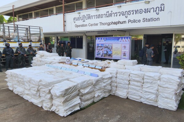 Thai soldiers stand beside seized 50 million methamphetamine pills hidden in sacks during a news conference at Thongphaphum Police station in Kanchanaburi province, Thailand, Wednesday, Dec. 13, 2023. Thai police have seized what is being called a record haul of methamphetamine tablets in the western province of Kanchanaburi, close to the Myanmar border. (AP Photo/Keskawe Chongchareon)