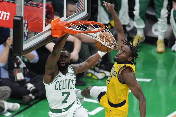 Boston Celtics guard Jaylen Brown (7) dunks the ball against Indiana Pacers forward Aaron Nesmith (23) during the first quarter of Game 1 of the NBA Eastern Conference basketball finals, Tuesday, May 21, 2024, in Boston. (AP Photo/Michael Dwyer)