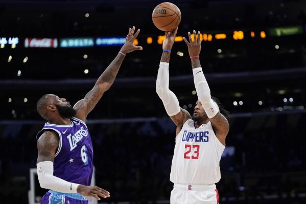 Los Angeles Clippers forward Robert Covington, right, shoots as Los Angeles Lakers forward LeBron James defends during the first half of an NBA basketball game Friday, Feb. 25, 2022, in Los Angeles. (AP Photo/Mark J. Terrill)