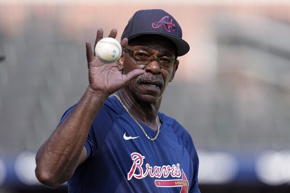 FILE - Atlanta Braves third base coach Ron Washington (37) reaches for a ball before a baseball game against the New York Mets Monday, Aug. 21, 2023, in Atlanta. The Los Angeles Angels have hired Washington to be their new manager. The 71-year-old Washington managed the Texas Rangers from 2007-14, winning two AL pennants and going 664–611. He spent the past seven seasons as Atlanta’s third base coach, helping the Braves to their 2021 World Series title. (AP Photo/John Bazemore, File)