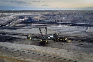 FILE - A bucket wheel excavator is mining coal at the Garzweiler open-cast coal mine with wind turbines in the background in Luetzerath, Germany, on Nov. 2, 2022. Coal use across the world is set to reach a new record this year amid persistently high demand for the heavily polluting fossil fuel, the International Energy Agency said Friday, Dec. 16, 2022.The Paris-based agency said in a new report that while coal use grew by only 1.2% in 2022, the increase pushed it to all all-time high of more than 8 billion metric tons, beating the previous record set in 2013. (AP Photo/Michael Probst)