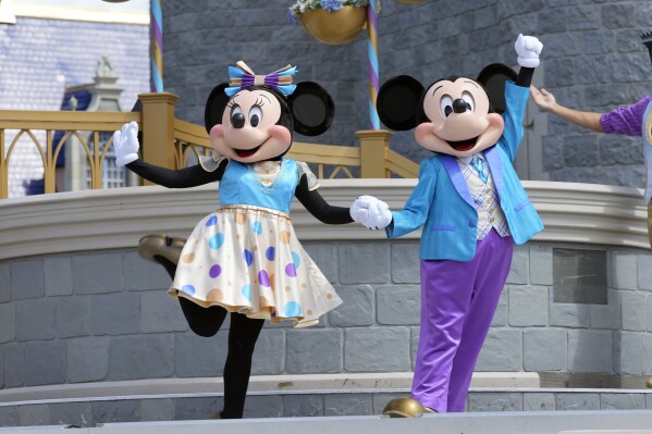 FILE - Minnie and Mickey Mouse perform for guests during a musical show in the Magic Kingdom at Walt Disney World, July 14, 2023, in Lake Buena Vista, Fla. Disney has requested a second court delay in its legal battle with Florida Gov. Ron DeSantis’ appointees over who controls Walt Disney World’s governing district. The request this week comes as the company is accusing the appointees and the governor’s office of failing to produce documents it had requested as part of the litigation. (AP Photo/John Raoux, File)