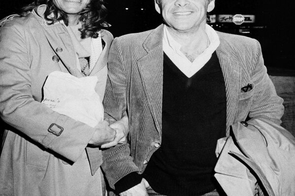 
              FILE - In this Nov. 28, 1980 file photo, Chuck Barris, host of the television's "Gong Show," and Robin Altman leave the Pierre Hotel in New York. Game show impresario Barris has died at 87. Barris, the madcap producer of "The Gong Show" and "The Dating Game," died of natural causes Tuesday afternoon, March 21, 2017, at his home in Palisades, New York. (AP Photo/Sands, File)
            
