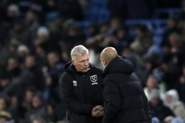 West Ham's manager David Moyes, left, shakes hands with Manchester City's head coach Pep Guardiola at the end of the English Premier League soccer match between Manchester City and West Ham United at the Etihad stadium in Manchester, England, Sunday, Nov. 28, 2021. (AP Photo/Scott Heppell)