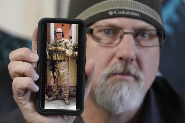 Matthew Butler, who spent 27 years in the Army, holds a 2014 photograph of himself during his last deployment in Kabul Afghanistan, on Wednesday, March 30, 2022, in Sandy, Utah. Butler is now one of the military veterans in several U.S. states who are helping convince conservative lawmakers to take cautious steps toward allowing the therapeutic use of hallucinogenic mushrooms and other psychedelic drugs. The therapeutic used of so-called magic mushrooms and other psychedelic drugs is making inroads in several U.S. states, including some with conservative leaders, as new research points to their therapeutic value and military veterans who have used them to treat post-traumatic stress disorder become advocates. (AP Photo/Rick Bowmer)