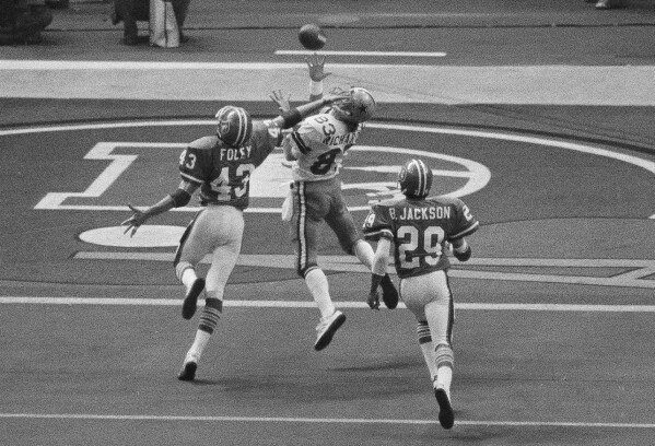 FILE - Despite the effort of Denver Broncos defensive back Steve Foley (43), Dallas Cowboys wide receiver Golden Richards hauls in a touchdown pass during NFL football's Super Bowl 12 in New Orleans on Jan 15, 1978. Richards died Friday, Feb. 23, 2024, of congestive heart failure at his home in Murray, Utah. He was 73. Richards' nephew Lance Richards confirmed his death in a post on his Facebook page. (AP Photo, File)