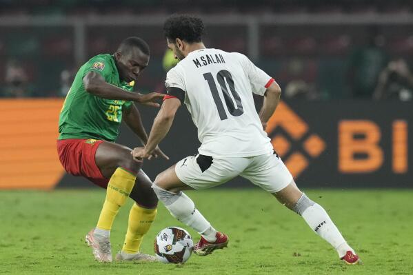 Cameroon's Nouhou Tolo, left, defends against Egypt's Mohamed Salah during the African Cup of Nations 2022 semifinal soccer match between Cameroon and Egypt at the Olembe stadium in Yaounde, Cameroon, Thursday, Feb. 3, 2022. (AP Photo/Themba Hadebe)