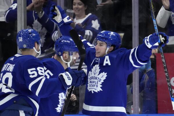 Toronto Maple Leafs right wing Mitchell Marner (16) celebrates his goal with teammates Michael Bunting (58) and Mark Giordano (55)  during first period NHL hockey game in Toronto, Sunday, April 17, 2022. (Frank Gunn/The Canadian Press via AP)