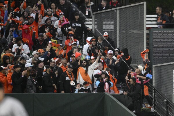 Baltimore Orioles owner David Rubenstein (wearing white cap), lower right, sprays the crowd during a baseball game between the Orioles and the Arizona Diamondbacks, Friday, May 10, 2024, in Baltimore. (AP Photo/Nick Wass)