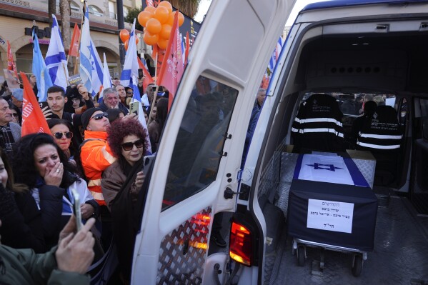 Mourners gather around the car carrying the coffins of slain hostages Shiri Bibas and her two children, Ariel and Kfir, during their funeral procession in Rishon Lezion, Israel, Wednesday, Feb. 26, 2025. (AP Photo/Ariel Schalit)