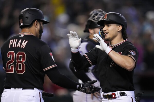 Arizona Diamondbacks' Alek Thomas, right, smiles as he celebrates his three-run home run with Tommy Pham (28) during the third inning of a baseball game against the Colorado Rockies, Wednesday, Sept. 6, 2023, in Phoenix. (AP Photo/Ross D. Franklin)