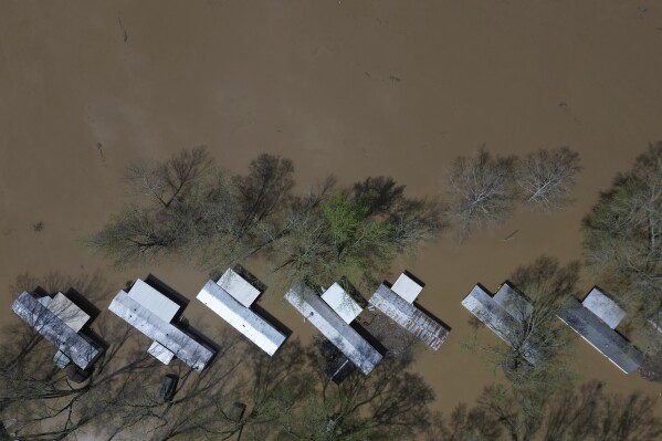 A mobile home park floods where rising waters of the Little Sugar Creek meet the Ohio River, Monday, April 7, 2025, in Napoleon, Ky. (AP Photo/Carolyn Kaster)
