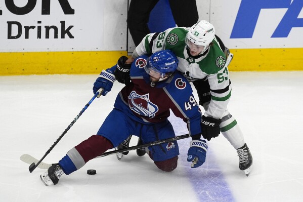 Colorado Avalanche defenseman Samuel Girard (49) gets tangled up with Dallas Stars center Wyatt Johnston (53) in the third period of Game 4 of an NHL hockey Stanley Cup playoff series Monday, May 13, 2024, in Denver. (AP Photo/David Zalubowski)