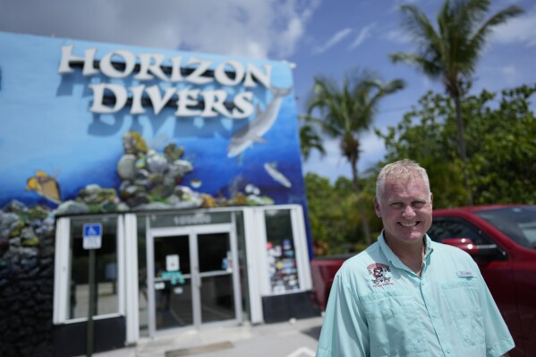 Dan Dawson, owner of Horizon Divers, poses outside his dive shop in Key Largo, Fla., Thursday, Aug. 17, 2023. Dawson saw business boom during the pandemic. Now it's back to pre-pandemic levels. (AP Photo/Rebecca Blackwell)