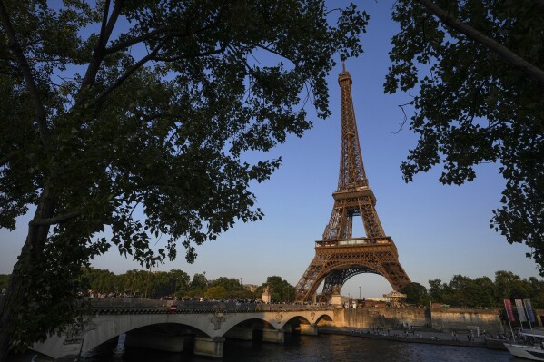 People walk on the Iena bridge leading to the Eiffel Tower in Paris, Thursday, June 1, 2023. The first Olympic Games since the ebb of the COVID-19 pandemic open in a year in France’s capital. (AP Photo/Michel Euler)