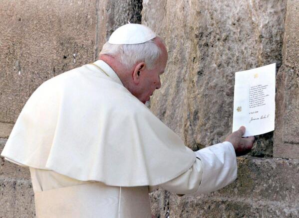 FILE - Pope John Paul II places a typed and signed note into a crack at the Western Wall Sunday, March 26, 2000, in Jerusalem's Old City. He tucked the prayer note into the wall asking God’s forgiveness for those who "have caused these children of yours to suffer.” (Gabriel Bouys/Pool Photo via AP, File)