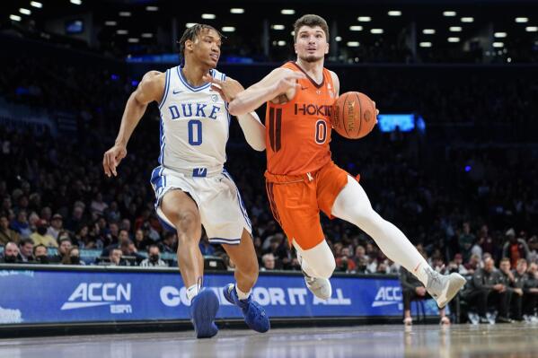 Virginia Tech's Hunter Cattoor, right, drives past Duke's Wendell Moore Jr., left, in the first half of an NCAA college basketball championship game of the Atlantic Coast Conference men's tournament, Saturday, March 12, 2022, in New York. (AP Photo/John Minchillo)
