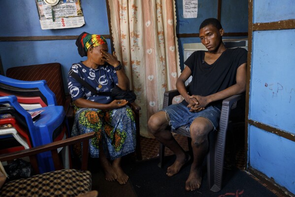 Memunatu Kamara breaks down in tears next to her son Mohammed, who smokes Kush in Susan's Bay, one of the three largest slums in Freetown, Sierra Leone, Sunday, April 28, 2024. Kamala said it's a shame for her to see her son going wasteful due to Kush's addiction. Sierra Leone declared a war on the cheap synthetic drug, calling it an epidemic and a national threat. The drug is ravaging youth, and healthcare services are severely limited. (AP Photo/ Misper Apawu)