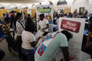FILE - Job applicants fill out forms with CSC Global, left, and Skilled Staffing, right, at the 305 Second Chance Job & Resource Expo, Friday, June 10, 2022, in Miami. America’s employers shrugged off high inflation and weakening growth to add 372,000 jobs in June, a surprisingly strong gain that will likely spur the Federal Reserve to keep sharply raising interest rates to try to cool the economy and slow price increases. The unemployment rate remained at 3.6% for a fourth straight month, the government said Friday, July 8.   (AP Photo/Lynne Sladky, File)