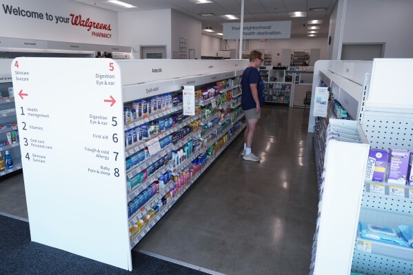 A customer browses an aisle at a Walgreens pharmacy store in Deerfield, Ill., Thursday, July 25, 2024. America's drugstores are testing smaller locations and making bigger bets on health care as they adjust to customers who need them less for convenience. (AP Photo/Nam Y. Huh)