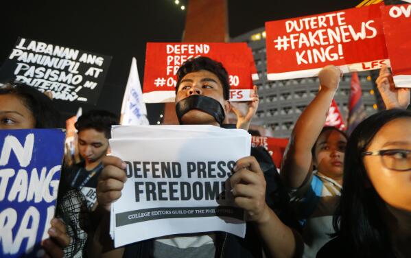 FILE - In this Jan. 19, 2018, file photo, journalists and supporters display their messages during a protest against the recent Securities and Exchange Commission's revocation of the registration of Rappler, an online news outfit, northeast of Manila, Philippines. (AP Photo/Bullit Marquez, File)