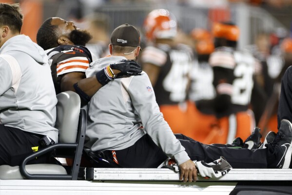 FILE - Cleveland Browns linebacker Anthony Walker Jr. (5) is taken off the field after being injured during the second half of an NFL football game against the Pittsburgh Steelers in Cleveland, Thursday, Sept. 22, 2022. No injuries cause more lost time in the NFL than those painful pulls and pesky strains of the leg muscles that give players the burst they need to keep up in this speed-based game. The league has committed millions of dollars to studying, treating and preventing these lower extremity injuries, seeing progress in minimizing the problems with the hamstring, quad, calf and the like. (AP Photo/Ron Schwane, File)