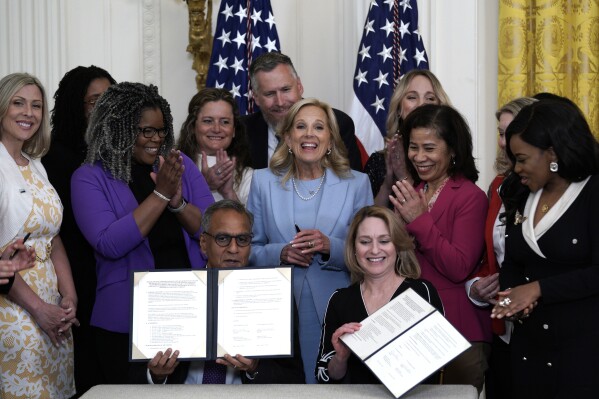 First lady Jill Biden reacts as Deputy Secretary of Defense Kathleen Hicks and Deputy Secretary of State Richard Verma sign a permanent memorandum of agreement between Defense Department and State Department to strengthen the Domestic Employees Teleworking Overseas (DETO) program for military spouses in the East Room at the White House, Wednesday, Apr. 17, 2024, in Washington. (AP Photo/Yuri Gripas)