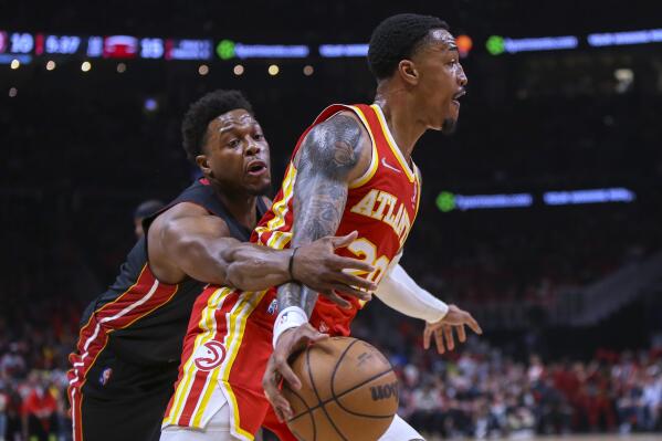 Miami Heat guard Kyle Lowry, left, attempts to steal the ball from Atlanta Hawks forward John Collins during the first half of Game 3 of an NBA basketball first-round Eastern Conference playoff series Friday, April 22, 2022, in Atlanta. (AP Photo/Brett Davis)